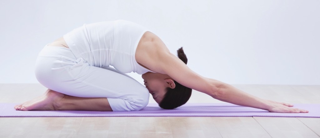 A woman with sciatica doing a child's pose yoga stretch