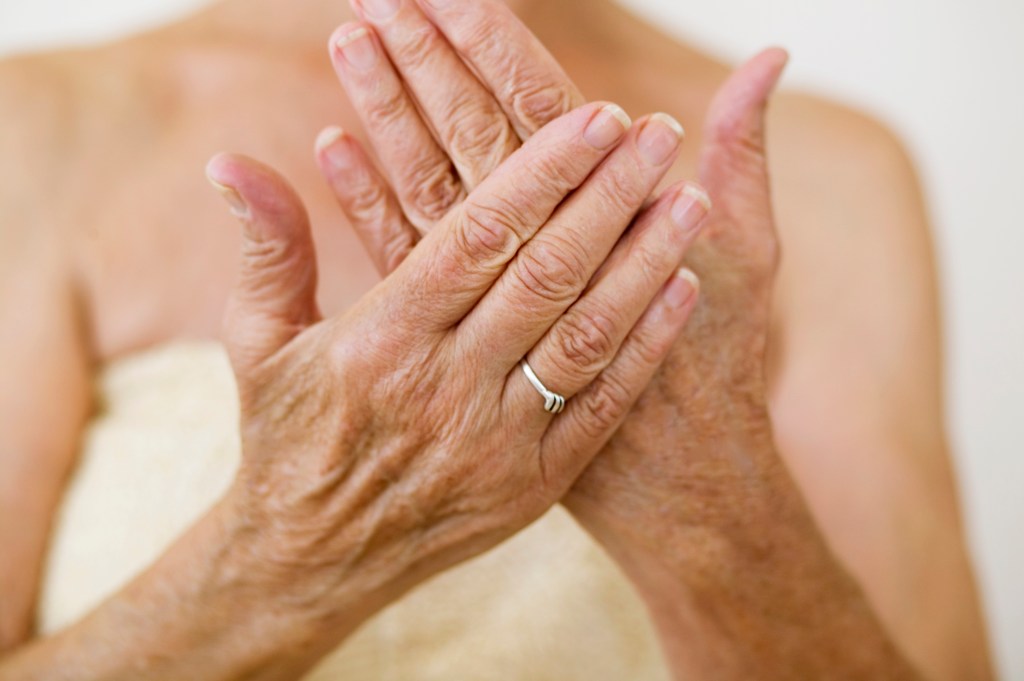 Mature woman overlaying crepey hands.