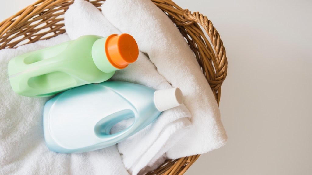 Blue and green bottles of laundry detergent in a wicker basket with white towels, which can cause armpit itchiness or a rash that does not signal cancer