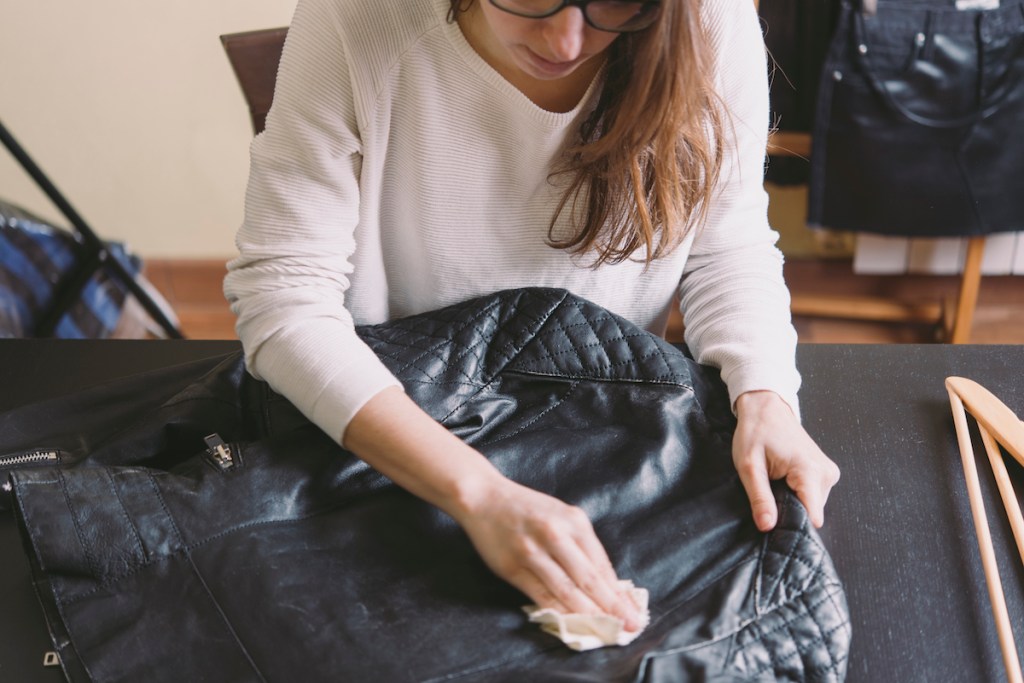 Woman cleaning leather jacket