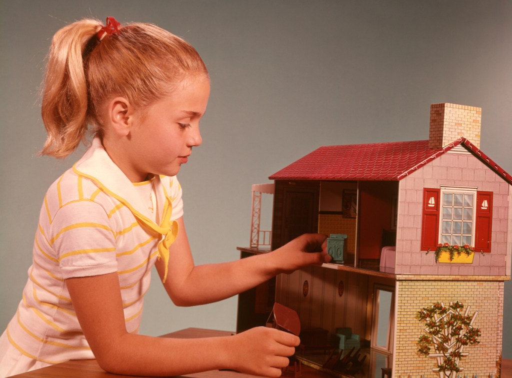 Girl playing with dollhouse in the '60s