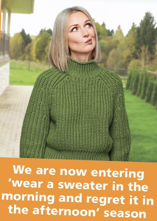Autumn jokes: a woman stands thinking about wearing a sweater