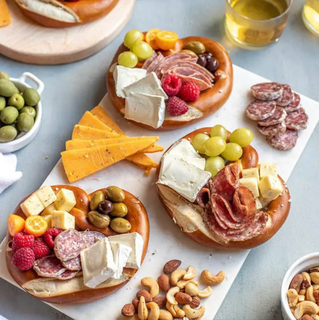 Oktoberfest party snack board that shows a medley of snacks displayed inside soft pretzels