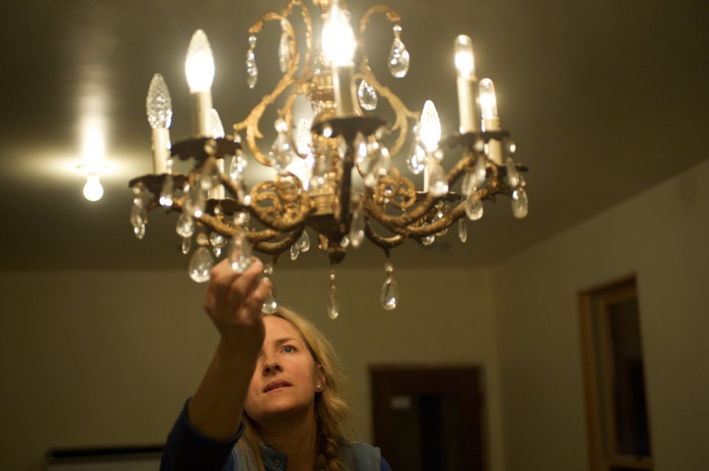 Woman cleaning glass on chandelier