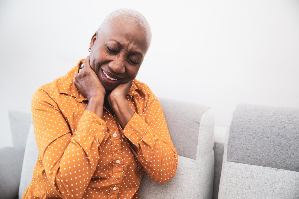 woman holding her neck in pain