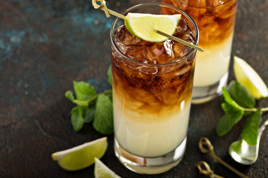 close-up of dark 'n' stormy drink in glass with lime wedge