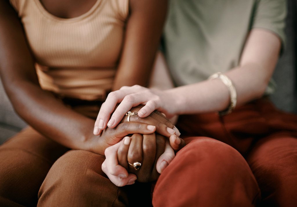 Closeup of two women holding hands with one another