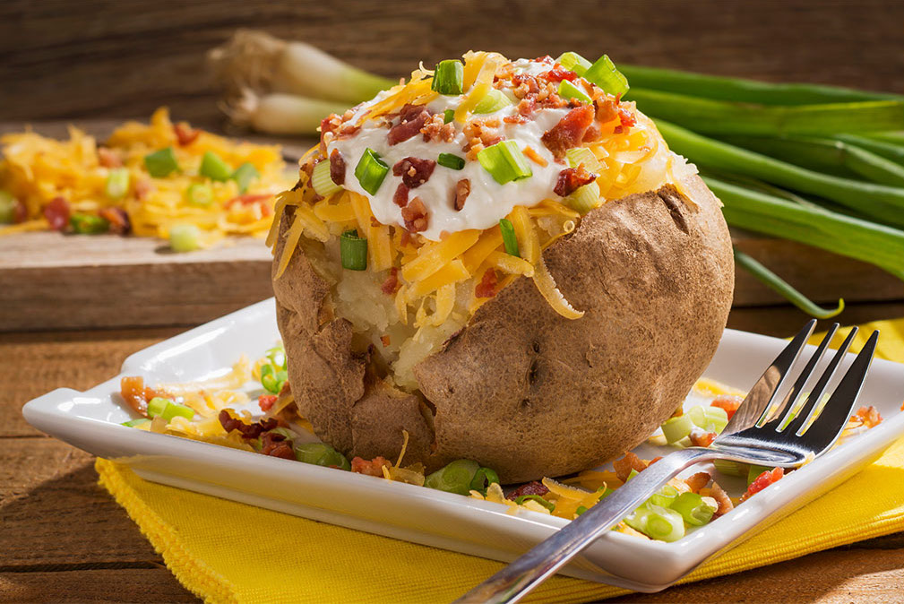Loaded baked potato stuffed with cheese and sour cream and bacon bits