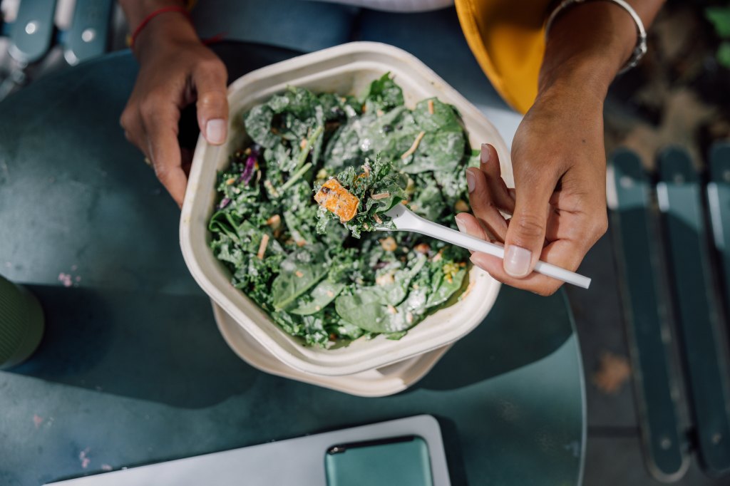 woman eating leafy green salad