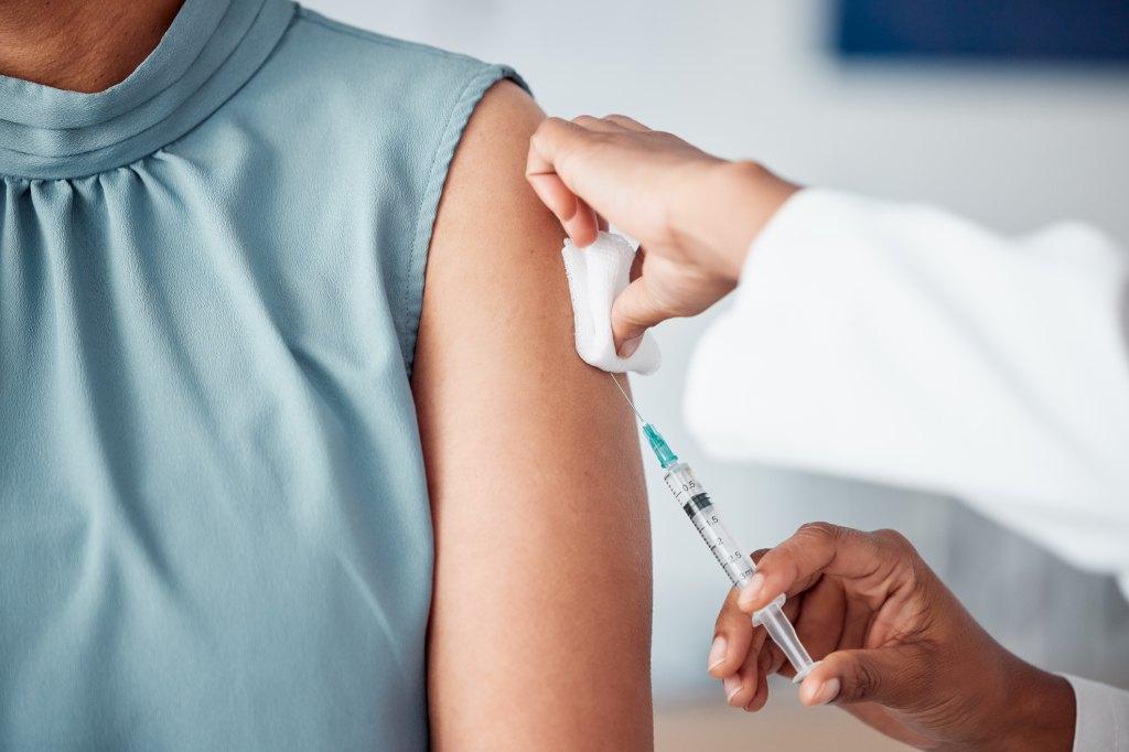 mature woman getting the flu shot at doctor's office