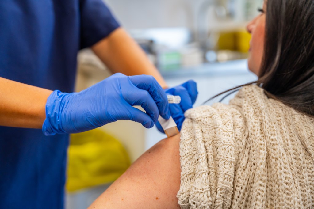 Mature woman getting the flu shot at her local pharmacy