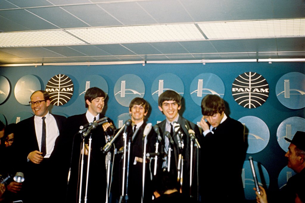 The Beatles (L-R Paul McCartney, Ringo Starr, George Harrison and John Lennon) hold their first US press conference at Kennedy Airport after arriving from London for a 10-day tour on February 7, 1964 in New York City, New York.