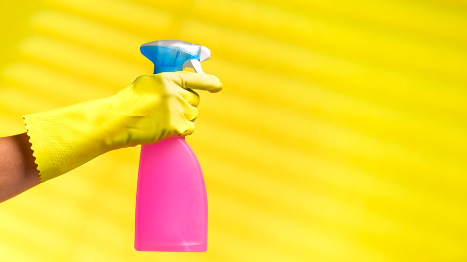 A bright pink spray bottle containing dish soap and vinegar
