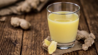 Ginger shots next to fresh ginger, which has health benefits