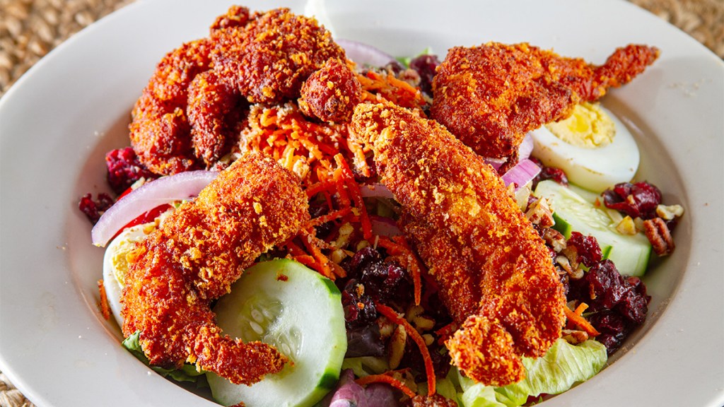 Hot honey chicken tenders served over a salad