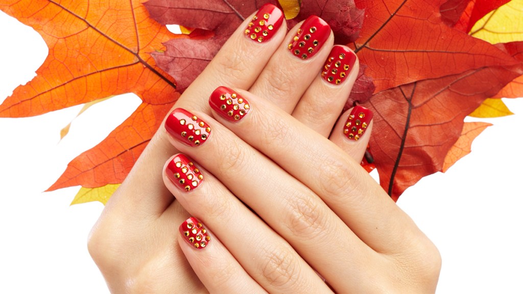 Red nails with gold rhinestones.