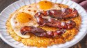 Strips of million dollar bacon on top of a hash brown and eggs