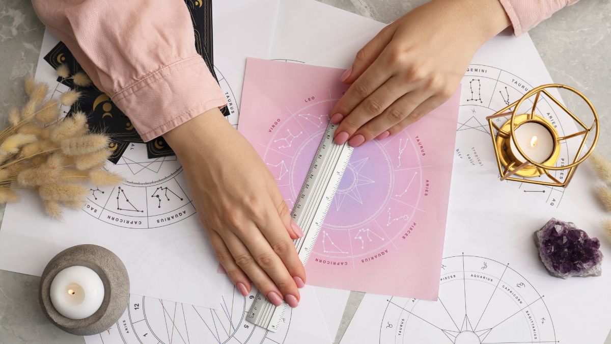 Astrologer using zodiac wheel for fate forecast at table, top view. Fortune telling