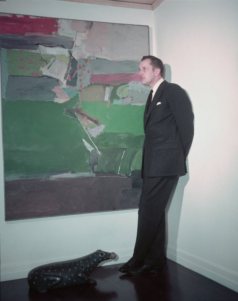 Vincent Price poses with a painting from his collection in 1955