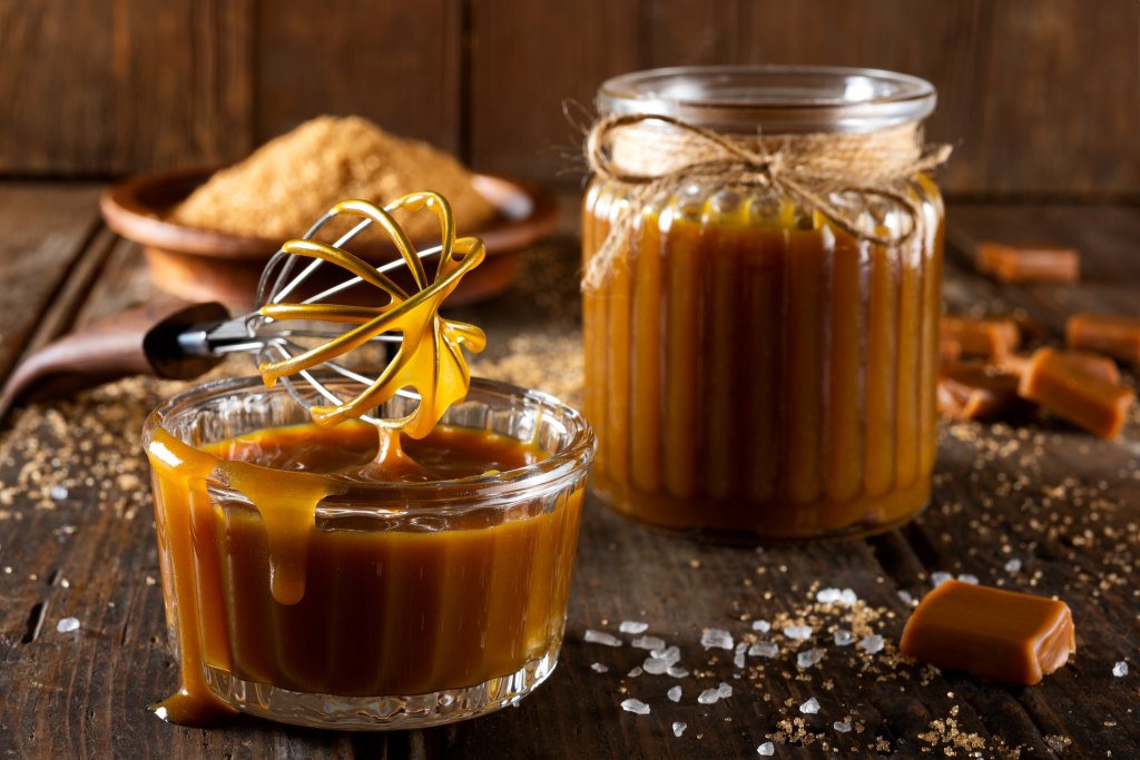 homemade caramel sauce in jar with whisk