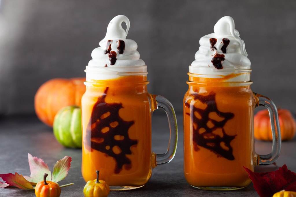 Halloween pumpkin patch mocktail with whipped cream and chocolate spider web