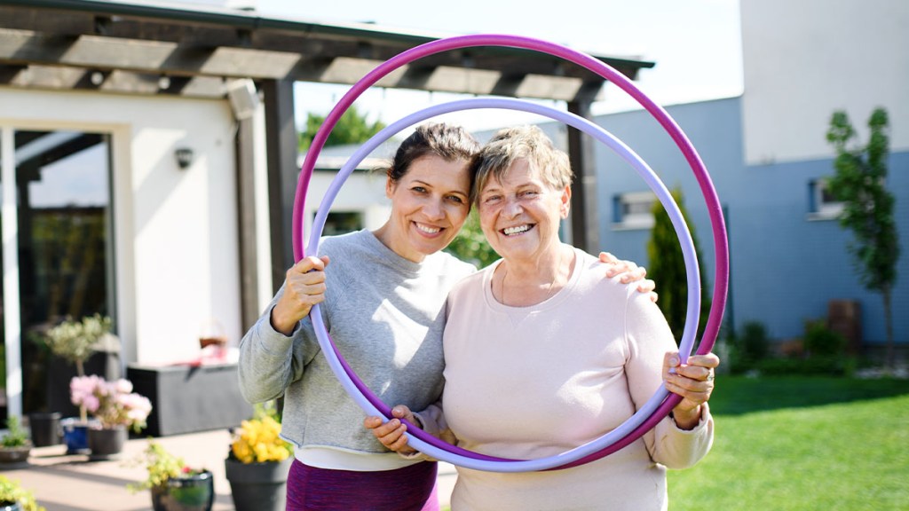 Two women holding weighted hula hoops to use for weight loss results