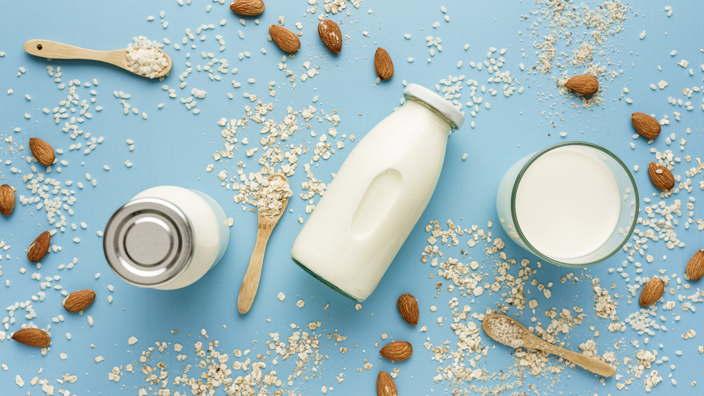 lactose-free alternative milk jars overlay with nuts