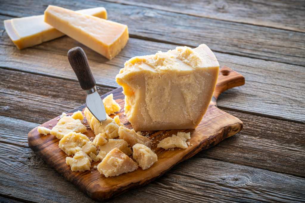 block of parmesan cheese on cutting board