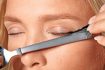 Woman using a spoon to create winged eyeliner