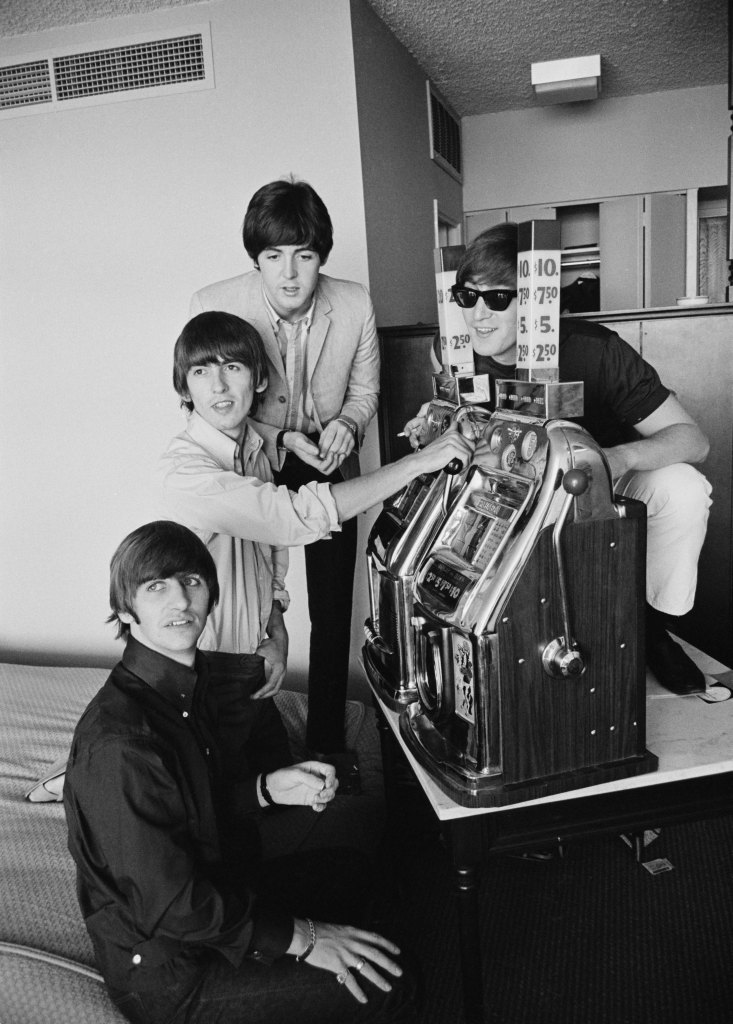 The Beatles try their luck on a pair of fruit machines, Las Vegas, 20th August 1964. Left to right: Ringo Starr, George Harrison (1943 - 2001), Paul McCartney and John Lennon (1940 - 1980). The Beatles are to play the Convention Hall later in the day. It will be the second date on their first US Tour.
