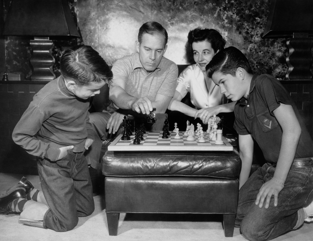 Harry Morgan playing chess with his wife Eileen and their sons, circa 1955.