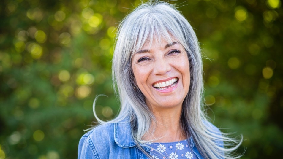 A grey haired woman smiling outdoors who doesn't want to take osteoporosis drugs