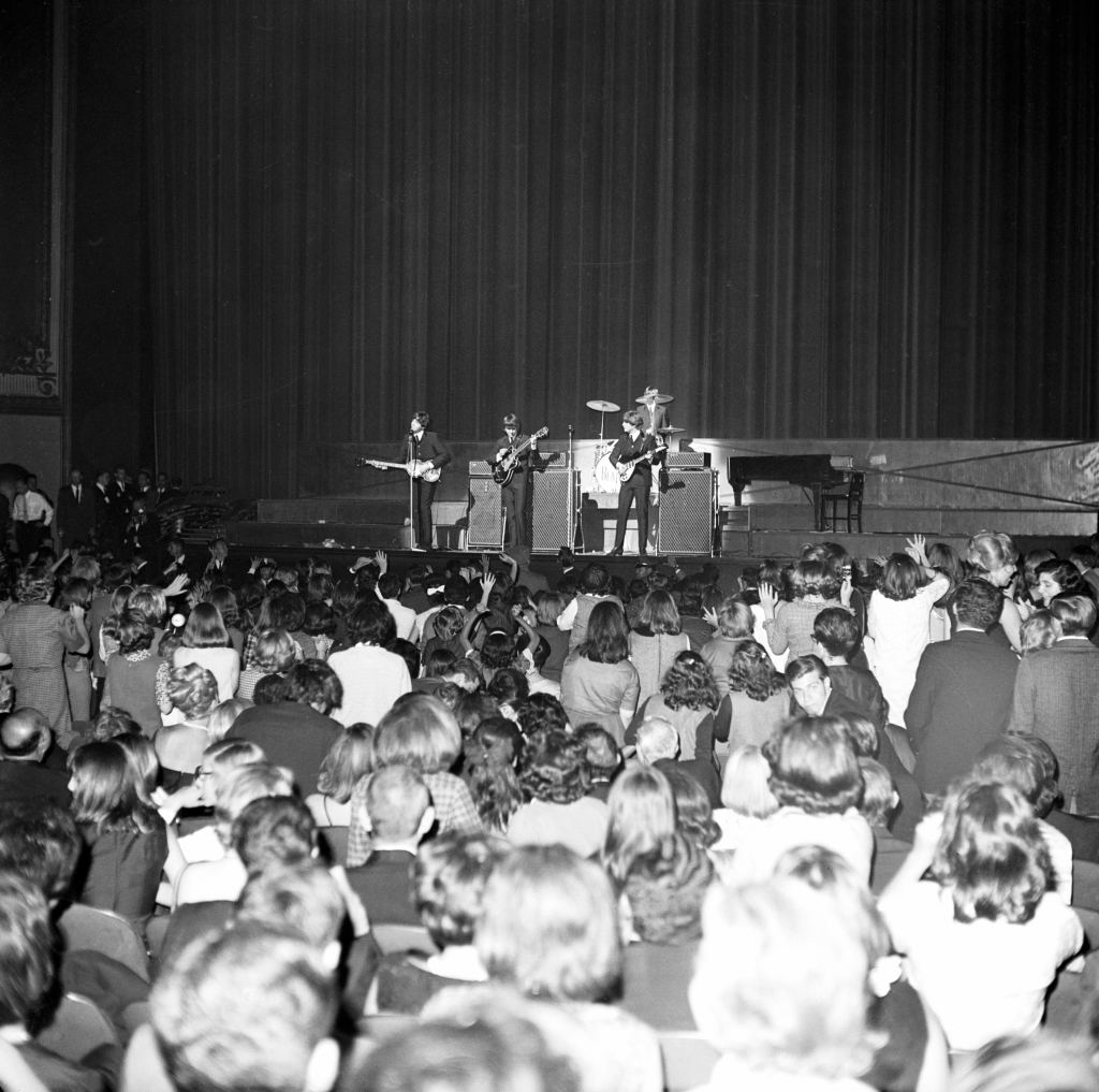 (Original Caption) 9/21/1964-New York, NY- England's famed mop-haired quartet, the Beatles, is in the spotlight during charity performance before an audience of screaming Beatlemaniacs (foreground) and dowdy Park Avenue matrons at New York's Paramount Theatre here 9/21. The performance by the Beatles, who sang their "swan song" in the U.S., will benefit United Cerebral Palsy. 