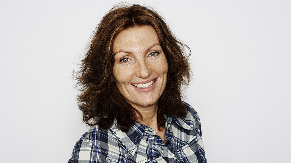 A woman in her 50s with lush brown hair that's thicker thanks to black seed oil