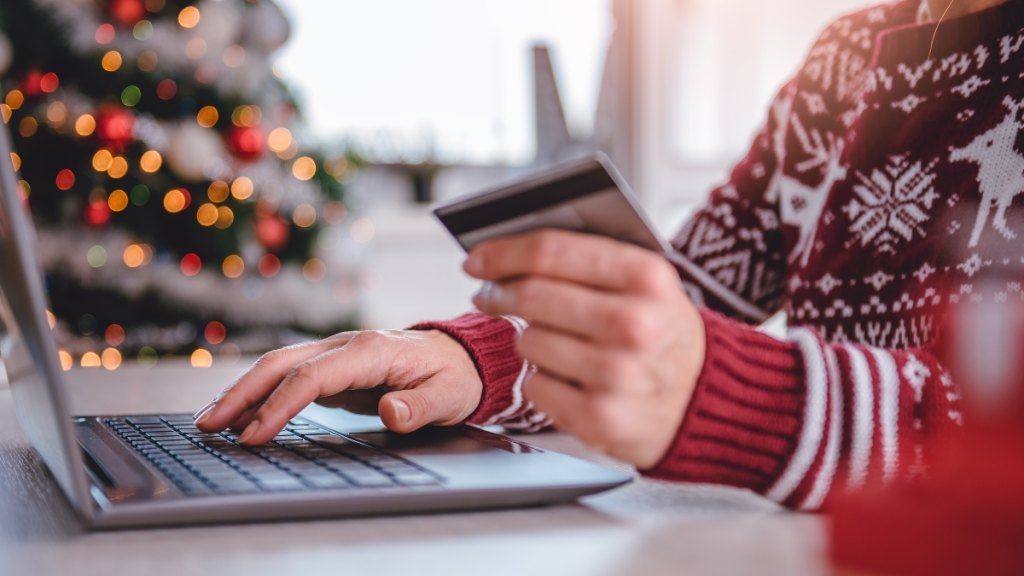 A woman holding a credit card and shopping online