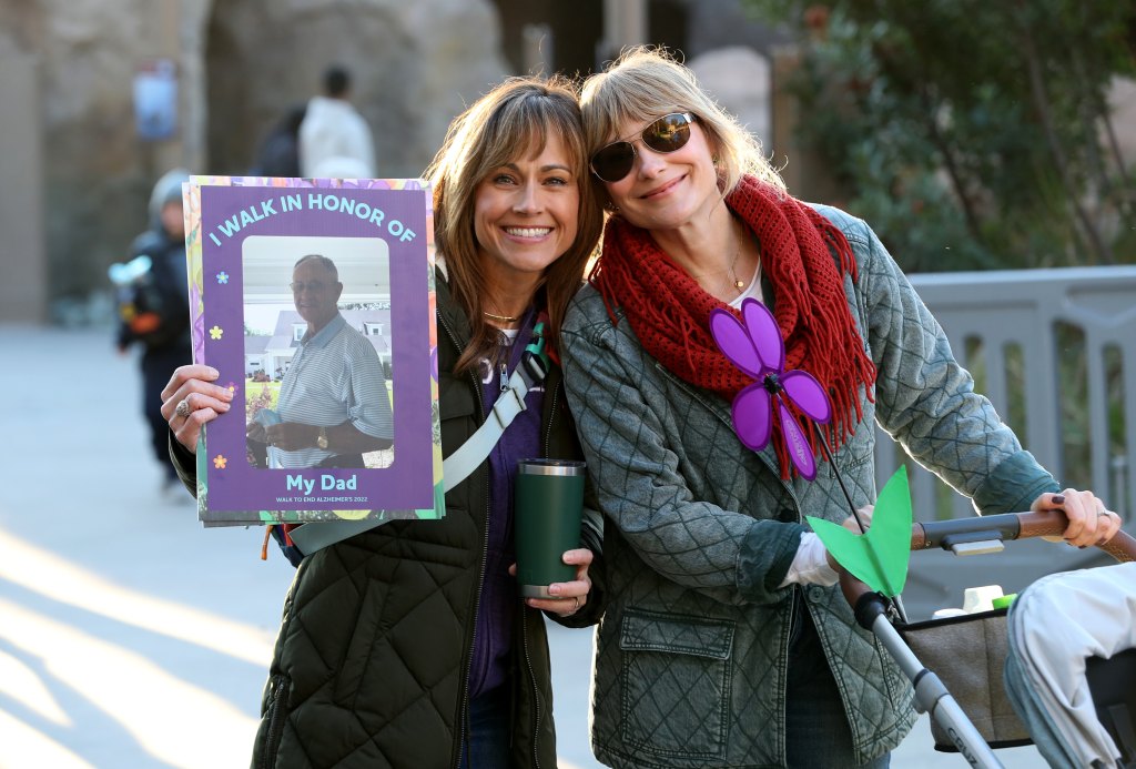 Nikki DeLoach holds a picture of her dad at the 2022 Walk to End Alzheimer's with fellow actress Jen DeDe