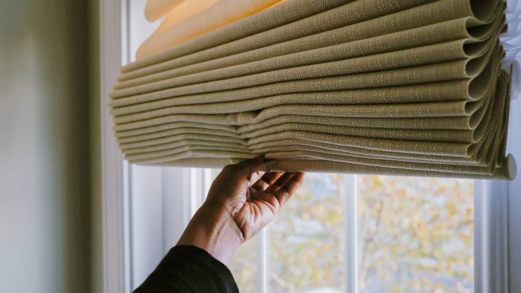 Woman adjusting fabric blinds