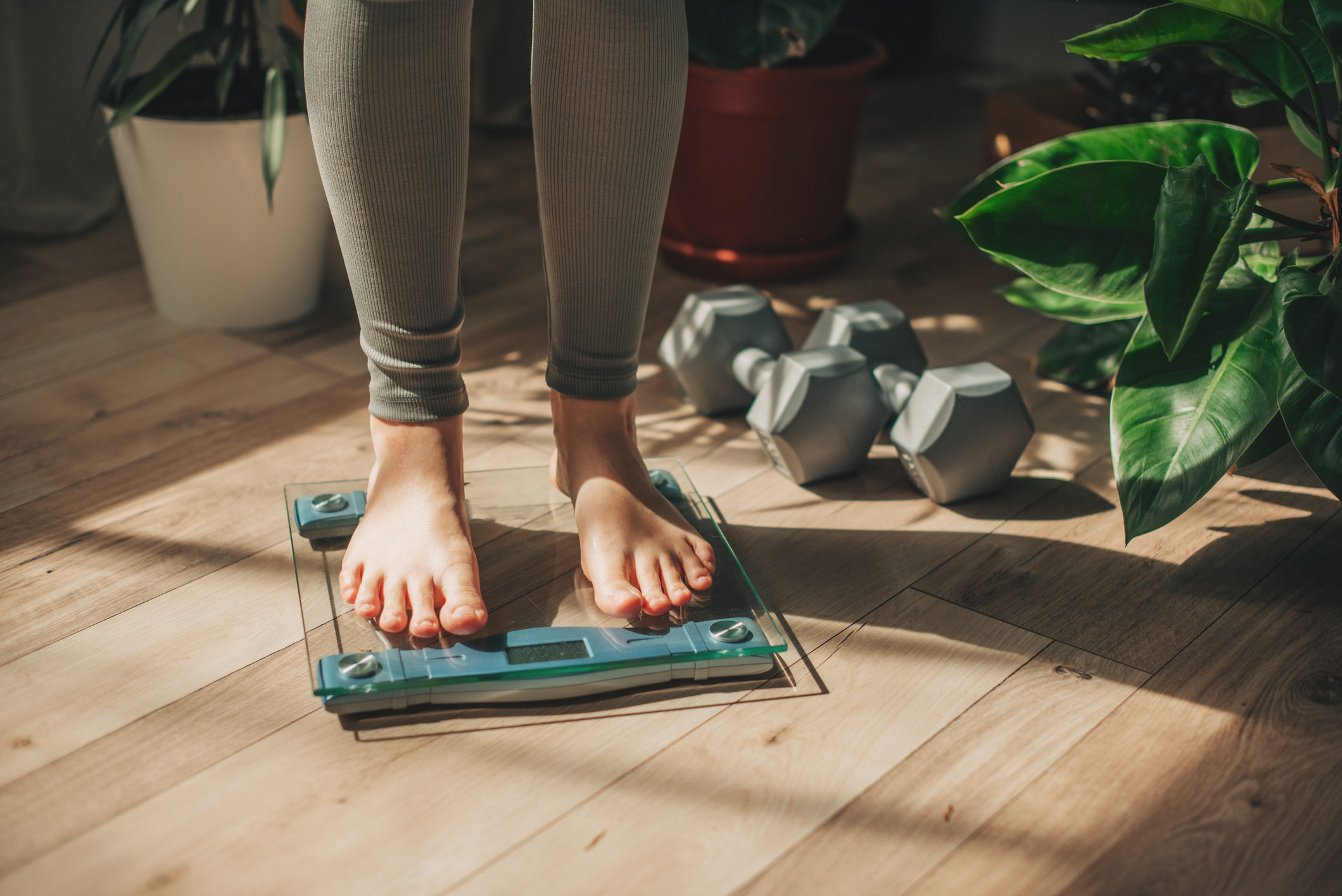 mature woman standing on scale weighing herself