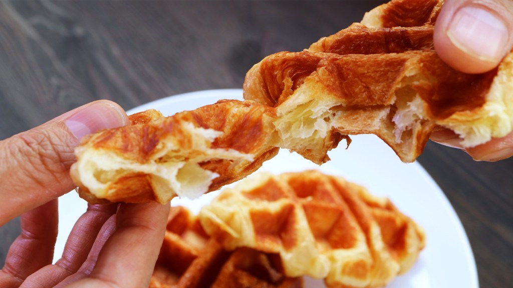 Croffle (or croissant waffle) being pulled apart, showing butter layers