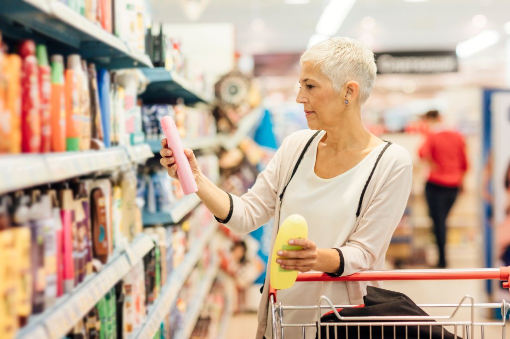 mature woman shopping for beauty products at grocery store