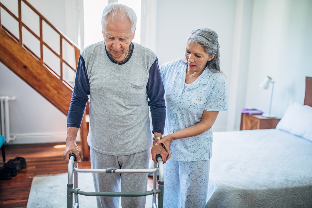 wife helping her husband with mobility walker