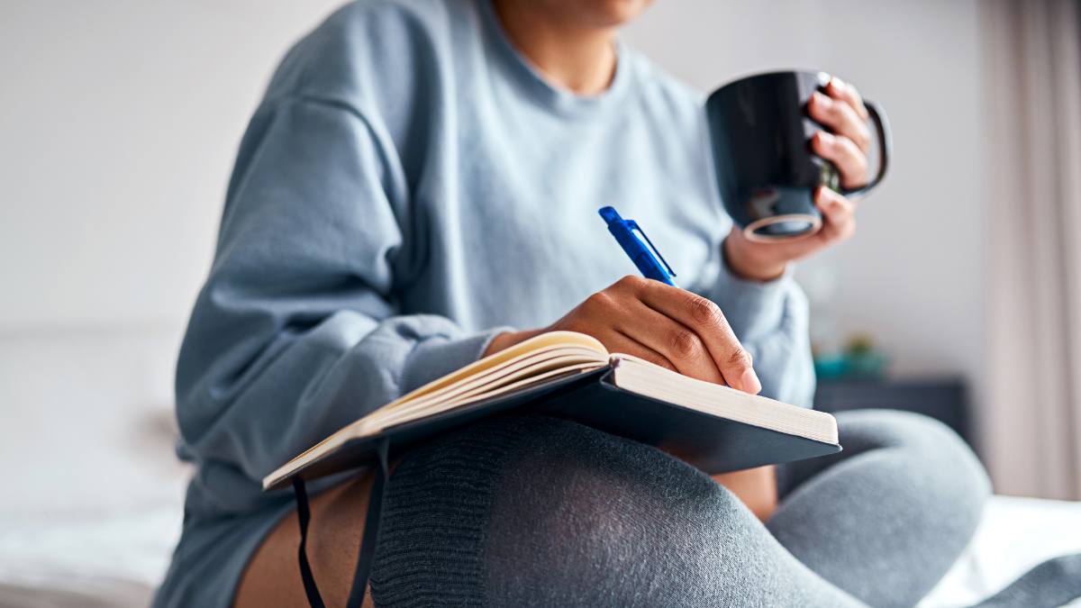 Woman writing in gratitude journal