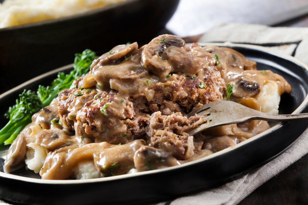 close up of salisbury steak with mushroom gravy sauce over mashed potatoes