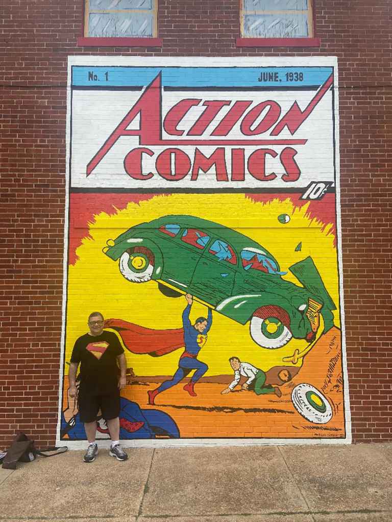 Ed besides a mural in Metropolis, IL during Superman Celebration 2024.