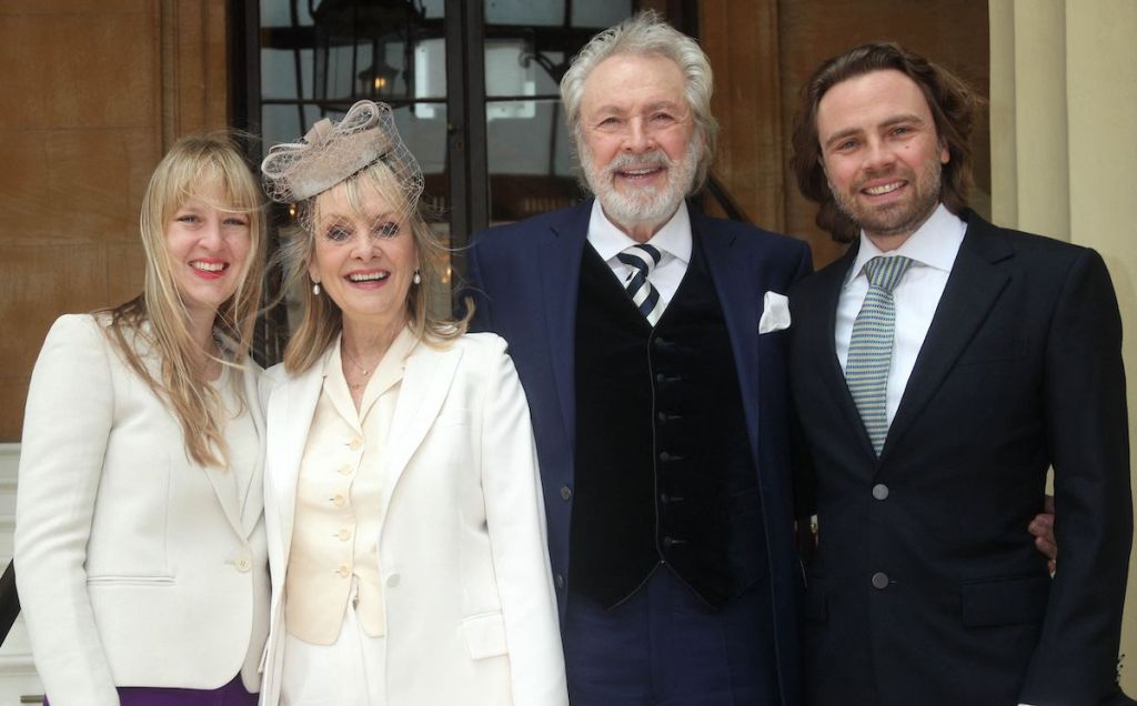 British supermodel Lesley Lawson (2L) poses with her husband Leigh (2R), son Jason (R) and daughter Carly (L), as she arrives at Buckingham Palace before attending an investiture ceremony in London on March 14, 2019 where she will be appointed a Dame Commander of the Order of the British Empire (DBE) for services to fashion, the arts and charity