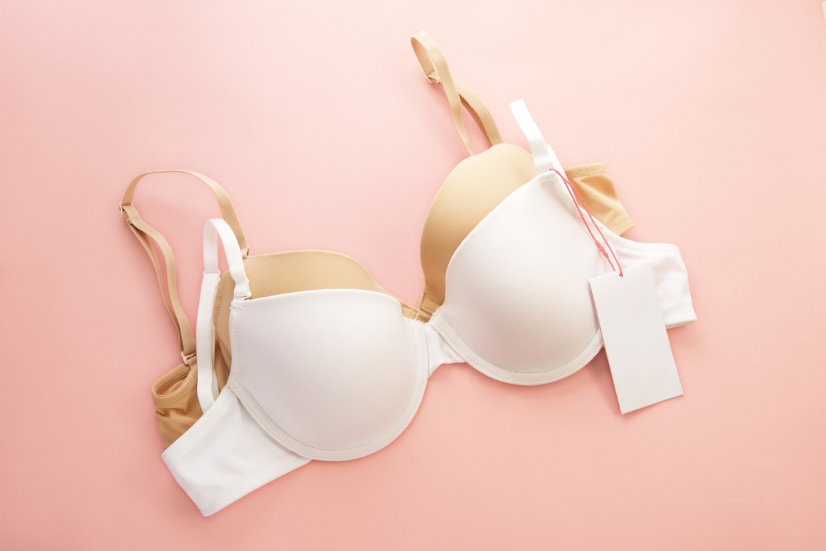 Women's bras with white paper labels on pink background