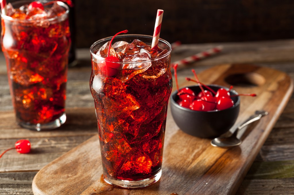 Cherry cola drink on wooden board