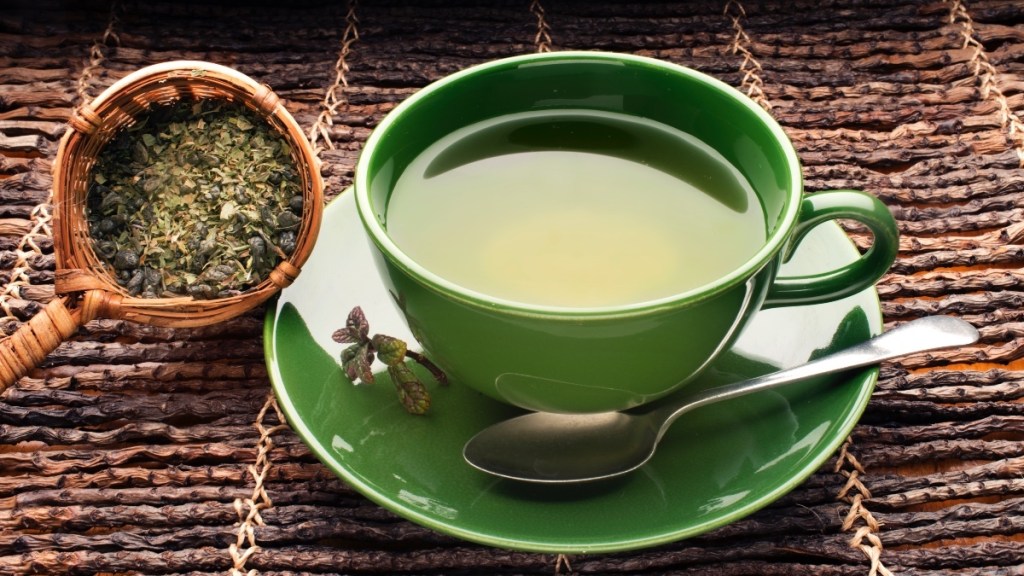 A cup of green tea on a wooden background