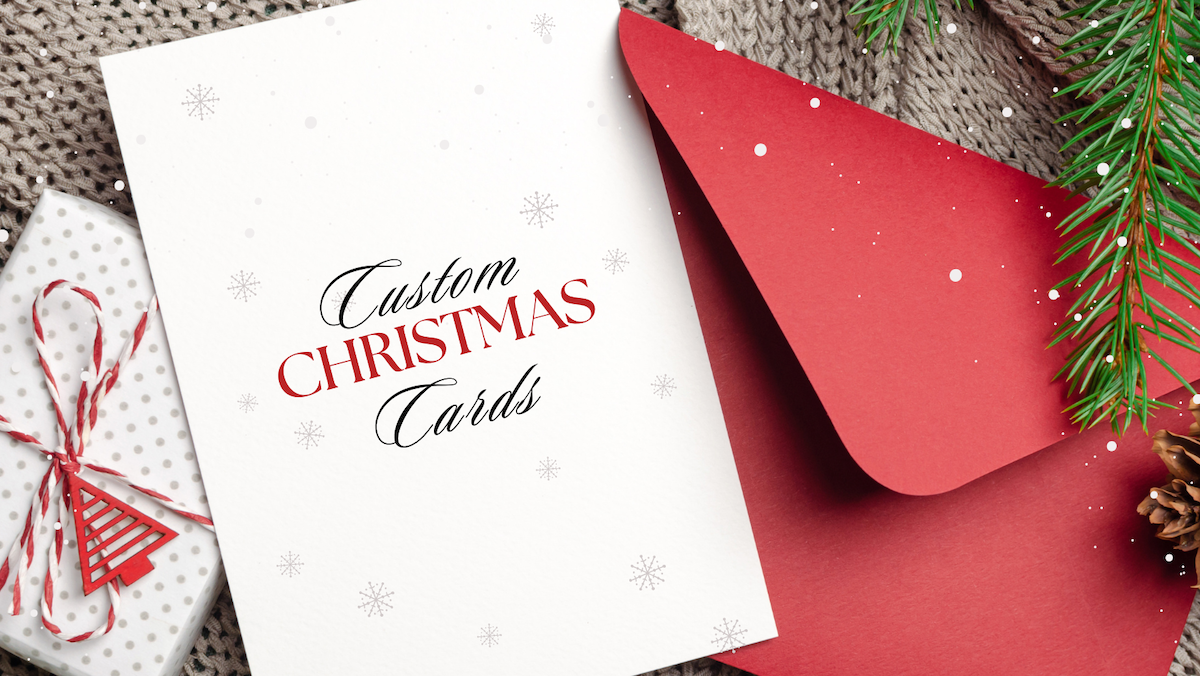 An image of a holiday card with snowflakes and a festive red envelope. The card reads 'Custom Christmas Cards.'