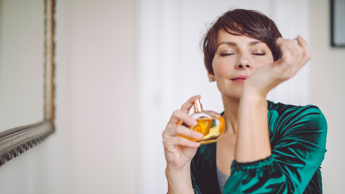 mature woman smelling perfume on wrist